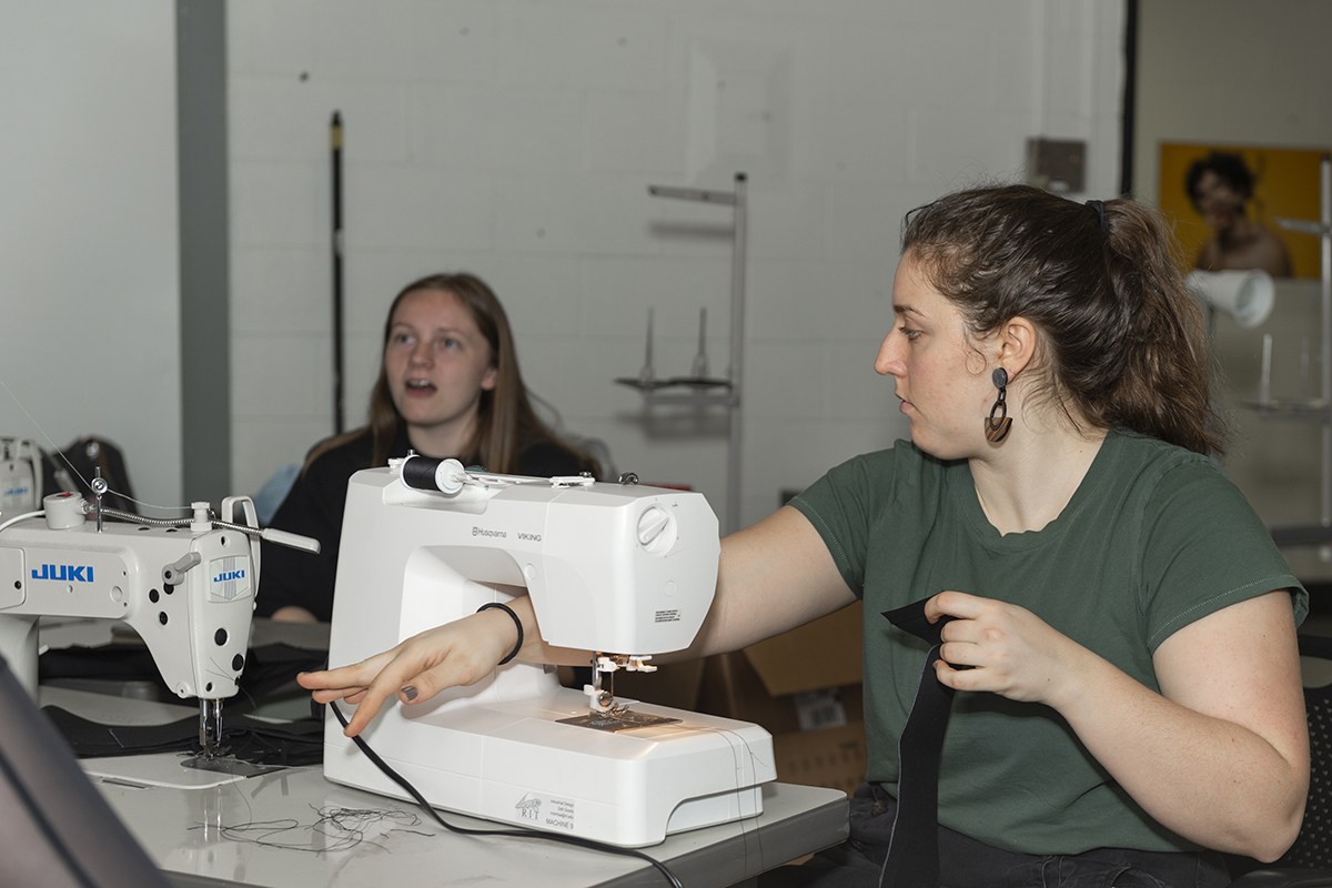 A student works on a sewing machine.